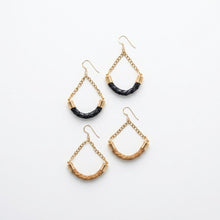 Set of gold and black earrings on a white background