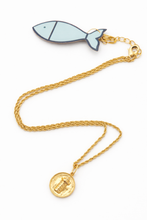 Necklace with fish-shaped pendant and gold chain on a white background