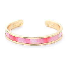 Gold bracelet with pink interior on a white background