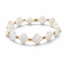 A beaded stretch bracelet featuring irregular white mother-of-pearl clover-shaped beads separated by small polished gold spacer beads, shown on a clean white background.