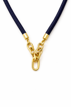 Navy blue rope necklace with a gold chain clasp on a white background