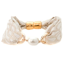 Beige woven bracelet with a gold clasp and pearl bead on a white background