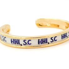 Gold bracelet with 'HHI, S.C.' text on a white background