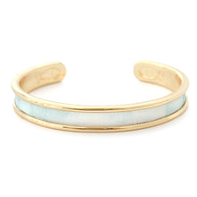Gold bracelet with a light blue band on a white background