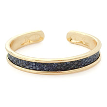 Gold bracelet with a blue stone inlay on a white background