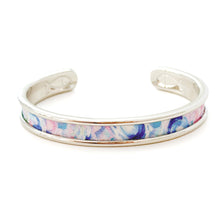 Silver bangle with a colorful pattern on a white background