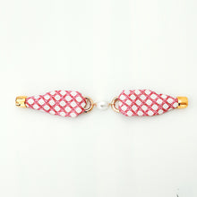 Pair of earrings with pink and white checkered design on a white background