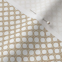 Close-up of fabric with circular pattern and plain white fabric, pinned together.
