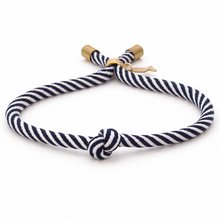 Navy and white striped bracelet with a knot on a white background