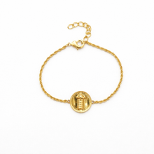 Gold bracelet with a circular charm on a white background