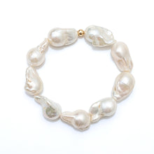 A baroque pearl beaded bracelet with irregular, organic-shaped pearls in shades of cream and off-white, accented by a small gold bead at the closure, shown on a plain white background.