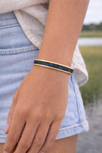 Person wearing a bracelet outdoors with a natural background