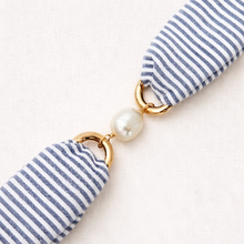 Blue and white striped keychain with a pearl charm on a light background