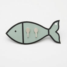 Fish-shaped jewelry holder with two earrings on a light gray background