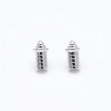 Pair of silver lighthouse-shaped earrings on a white background