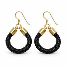 A pair of black braided leather hoop earrings with gold-tone metal ear wires and cylindrical connectors, shown on a plain white background.