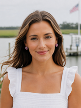 Woman wearing a white top with ruffled sleeves by a waterfront