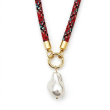 Necklace with red and black speckled cord and gold clasp on a white background