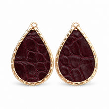 A pair of teardrop-shaped earrings featuring deep burgundy crocodile-embossed leather inlays set in textured gold-tone metal, shown against a plain white background. GAMECOCKS