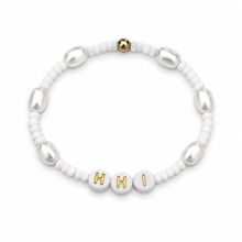 White beaded bracelet with gold letter beads on a white background