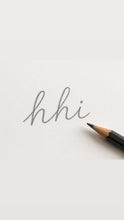Handwritten lowercase hhi script beside a pencil on pale paper.