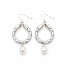 Silver hoop earrings with pearl drops on a white background