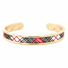 A gold-plated cuff bracelet featuring a central inlay of a red, black, white, and yellow tartan plaid pattern, shown on a plain white background.