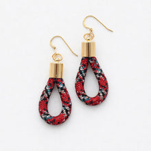 Pair of earrings with red and black plaid design on a white background