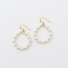 Pair of pearl hoop earrings on a light gray background