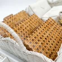 Basket with gold jewelry and a white box on a light background
