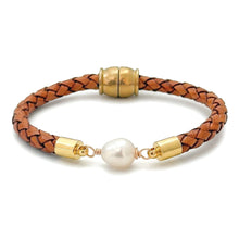 A braided brown leather bracelet with gold-toned metal caps and a central white freshwater pearl, displayed on a clean white background.