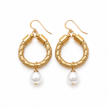 Gold hoop earrings with pearl drops on a white background