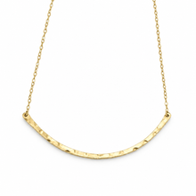 A gold necklace featuring a hammered, textured semi-circular bar suspended from a delicate gold chain, shown against a plain white background.