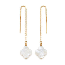 A pair of gold-toned dangle earrings with slender chain drops and white mother-of-pearl clover-shaped pendants, shown on a plain white background.