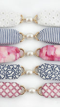 Set of decorative hair ties with fabric and pearl accents on a white background