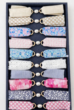 Set of fabric hair ties in various patterns and colors arranged in a black box.