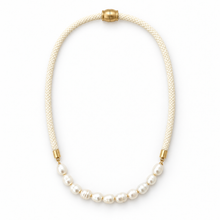 A pearl necklace with a cream braided cord and gold-tone metal accents, displayed on a clean white background.