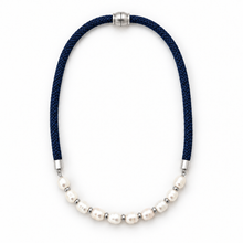 A necklace featuring a dark navy blue braided cord and a row of white freshwater pearls separated by small silver spacer beads, shown on a plain white background.