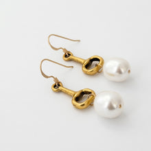 Gold earrings with pearls on a white background
