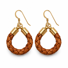 A pair of handmade hoop earrings featuring braided brown leather loops with gold-toned metal caps and fishhook ear wires, displayed on a clean white background.