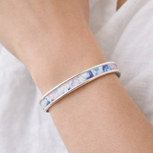 Multicolored bracelet on a person's wrist against a white background