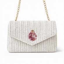 White knit handbag with a shell charm on a white background