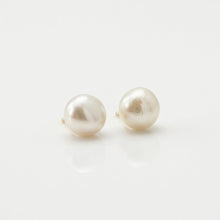 Pair of pearl earrings on a light gray background