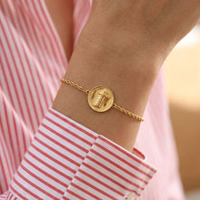 Gold bracelet on a wrist with a blurred background