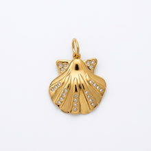 Gold shell pendant with embedded stones on a white background