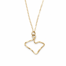 A gold chain necklace featuring an open, hammered-texture pendant shaped like a stylized heart or abstract silhouette, shown against a plain white background.