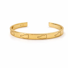 Gold bracelet with engraved designs on a white background