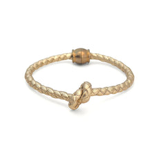 Gold bracelet with a knot design on a white background