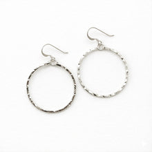 Pair of silver hoop earrings on a white background