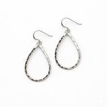 Pair of silver teardrop earrings on a white background